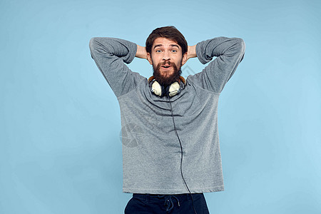 男人戴着耳机音乐情感生活方式现代风格科技蓝色背景工作室青年闲暇娱乐快乐乐趣喜悦幸福男性音乐播放器图片