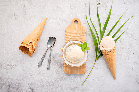 半块椰子在白土上的椰子配方中的椰子冰淇淋口味糖果异国食物美食牛奶可可香草味道锥体酸奶图片