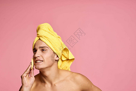 头上戴毛巾的男子和手掌上印有黄色海绵的人 将脸皮清洗干净微笑男生成人皮肤护理卫生身体温泉剃须浴室图片