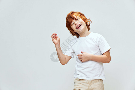 可爱的姜幼童 用手抚摸他的双手 张开笑容 头向一边倾斜图片