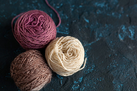 用于编织和编织的羊毛缝线 在深蓝色纹理质凝固混凝土上工艺团体生态爱好羊绒纺织品棉布工作羊驼手工图片