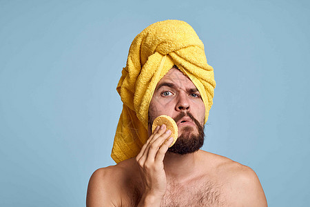 一个头戴黄色毛巾的男人流浪汉裸露的肩膀干净的皮肤正在洗澡卫生剃须微笑男生治疗成人头发浴室身体奶油图片