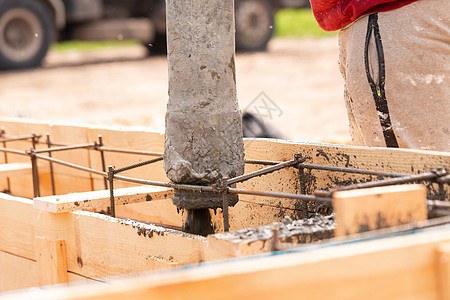 把水泥或混凝土用自动泵在基金会形式上铺设水泥或混凝土的建筑工人工人钢筋项目就业管道碎石技术建筑学建设者基础设施图片