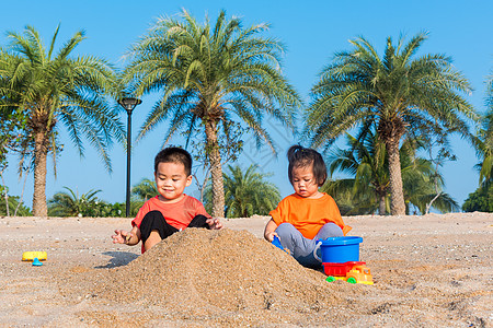 哥哥和妹妹两个孩子玩挖沙子玩玩具的滑稽挖掘乐趣女孩热带帽子海岸假期男生童年闲暇阳光图片