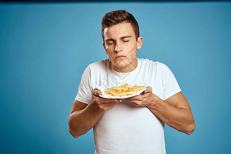 男人用硬纸板炸薯条卡路里快餐蓝色背景青少年模型裁剪视图脂肪汉堡午餐芝士胡子餐厅成人肥胖工人饮食图片