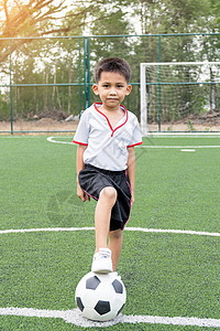 那个男孩在踢足球阳光乐趣管道联盟白色绿色男孩童年微笑足球图片