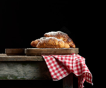 棕色厨房餐桌上的烤面包羊角面包 黑色背景糕点营养小吃脆皮红色甜点包子小麦餐巾食物图片
