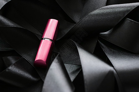 黑色丝绸背景的粉红口红 奢华化妆和美容皮革化妆品光泽度粉色女士魅力静物背景图片