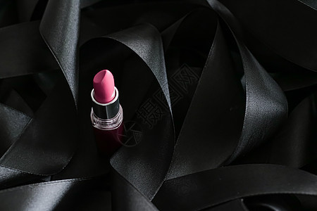 黑色丝绸背景的粉红口红 奢华化妆和美容女士光泽度化妆品静物粉色皮革魅力背景图片