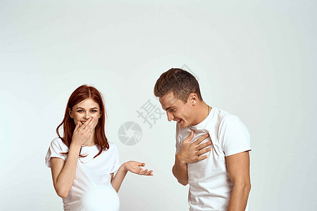 一个孕妇和一个年轻人在浅色背景下等待婴儿的情绪家庭爱生活家庭女士丈夫幸福母亲女性腹部父亲男人图片