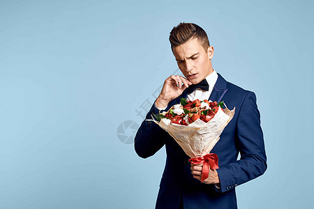 浪漫男人 有一束花朵和领结 在蓝色背景的风景下惊喜商务花束周年婚礼人士玫瑰男性纪念日男朋友图片