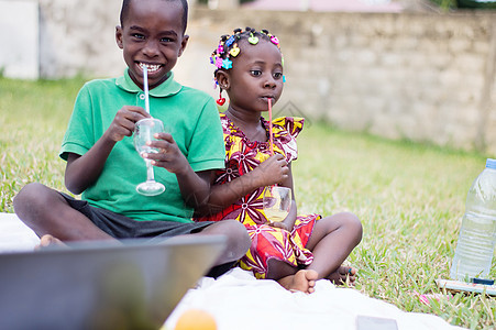 两名儿童坐着喝果汁图片