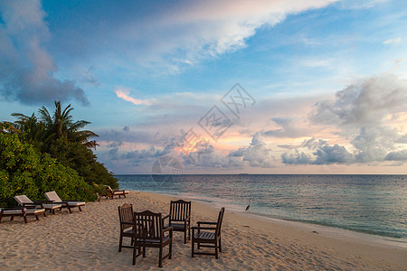 日出在海中一个小岛的海滩上热带日落海浪海洋天空椅子鳄鱼支撑闲暇太阳图片