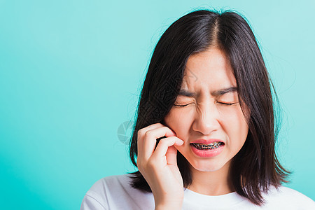 女人微笑 牙齿有牙牙套 笑着不开心的帕伊病人蓝色疼痛女孩矫正治疗成人卫生药品伤害图片