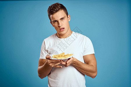 男人用硬纸板炸薯条卡路里快餐蓝色背景青少年模型裁剪视图脂肪营养汉堡午餐肥胖工人饮食成人餐厅男生图片