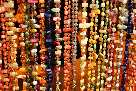 街头小店挂着五颜六色的水钻项链矿物树脂纪念品珠宝倾斜摊位纽扣街道礼物琥珀色图片