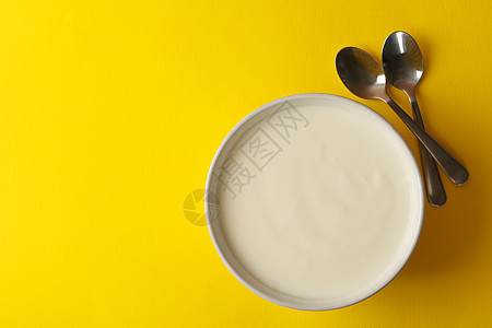 一碗酸奶油酸奶酸奶酸和黄底汤匙图片