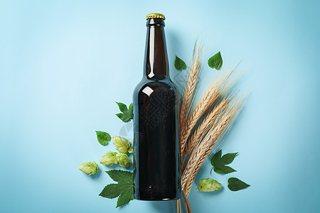 一瓶啤酒 小麦和蓝底酒食物啤酒厂泡沫酒精酒吧瓶子蓝色玻璃叶子杯子图片
