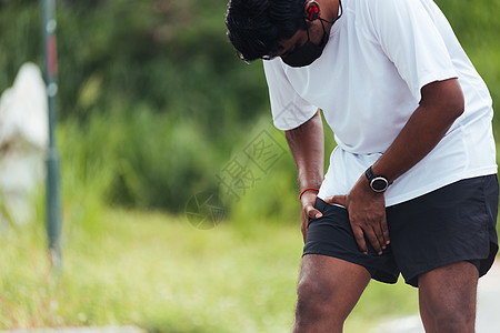 黑人男子穿着手表 握着她的腿 她有t老年男性事故膝盖伤害训练韧带大腿痛苦跑步图片