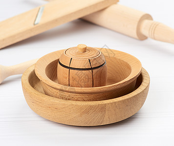 白桌背景上空的木制圆板堆叠圆圈烹饪白色餐具木板木头棕色勺子厨房用具图片