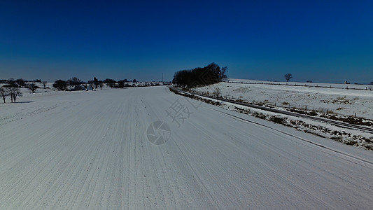 新鲜雪瀑落在田地上 有铁路路轨图片