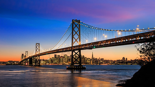 旧金山天际线和加州日落时湾桥图片