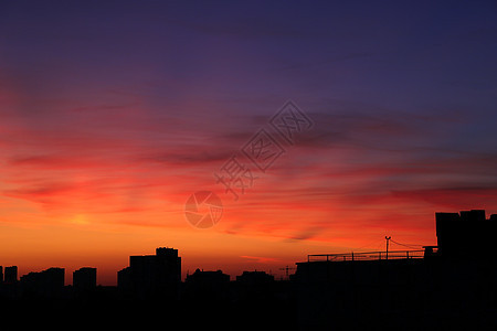 明亮的橙色夕阳在城市上空在晚上 城市高楼大厦灯火通明 在建建筑城市起重机剪影 选择性聚焦房子天空气氛日落风景天气太阳景观天际旅行图片