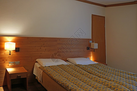 床边布满了装饰的缝隙 床边有灯台 卧室是生锈式的国家房间小屋木头软垫房子风格酒店乡村公寓图片