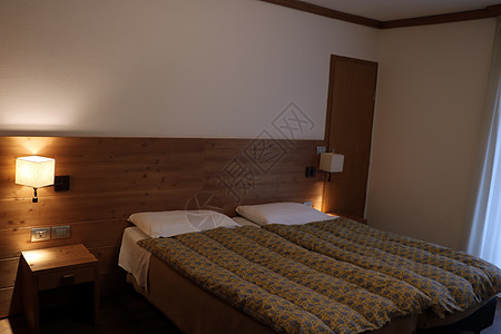 床边布满了装饰的缝隙 床边有灯台 卧室是生锈式的公寓桌子风格乡村房子枕头软垫木头房间蓝色图片