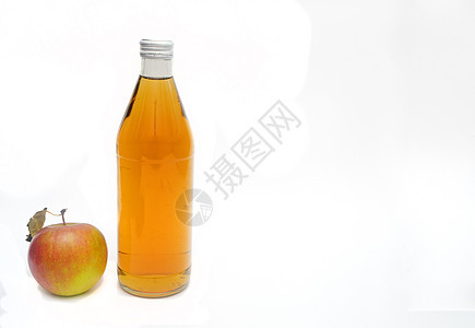 一整个苹果 有叶子 和一瓶苹果汁醋离子白色背景 复制空间图片