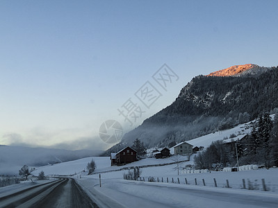 日出时驾车穿过挪威的山村村庄公路景观街道太阳天气太阳光线旅行森林农村图片