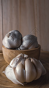 大蒜在木桌上的木碗中 以换取食物含量蔬菜营养灯泡叶子植物食谱味道白色烹饪美食图片