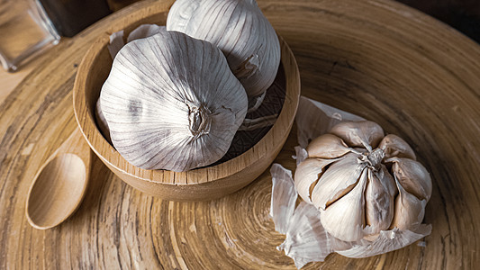大蒜在木桌上的木碗中 以换取食物含量叶子香料芳香食谱烹饪蔬菜味道美食灯泡木头图片