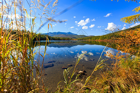 马加丹地区的性质 湖面美丽平坦 以彩色山丘和蓝天为背景 森林湖的迷人景色顶峰树木天空镜子木头风景季节海岸反射旅游图片