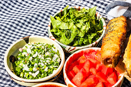 由香肠卷和不同碗盘组成的定律成分面包烹饪沙拉西红柿小吃糕点桌子木板洋葱午餐图片