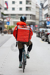 骑自行车送食物到市中心男性安全帽命令头盔公司骑术街道职业男人城市图片