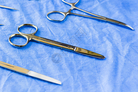 蓝色无菌桌上的外科剪刀眼科夹钳手术治疗镊子程序刀刃工具桌子剪子图片