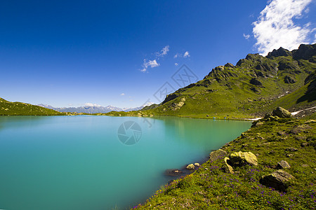 高山山脉湖风景和景观 蓝色美丽而惊人的湖泊全景海滩石头假期旅行背景反射太阳海岸天空场地图片