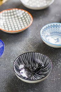 黑色背景的多彩碗食物盘子艺术设备蓝色桌子圆圈陶器厨房陶瓷图片