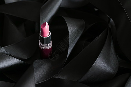 黑色丝绸背景的粉红口红 奢华化妆和美容粉色光泽度女士化妆品静物魅力皮革背景图片