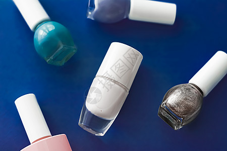 深蓝色背景 美容品牌的奈光油瓶子指甲奶油修脚玻璃博客化妆品蓝色粉色卫生抛光图片