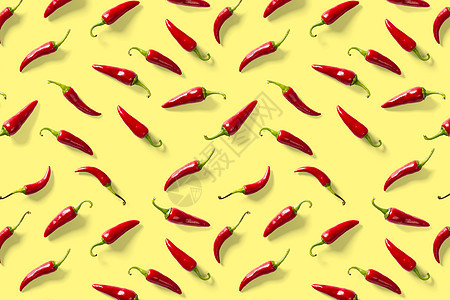 在黄色背景下由红辣椒或辣椒制成的创意背景 最小的食物背景 炽热的辣椒背景图片