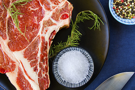 桌上的生牛肉肉 香料和迷迭香 利布眼睛牛排成分烹饪烧烤产品胡椒鱼片花椒桌子牛扒厨房炙烤图片