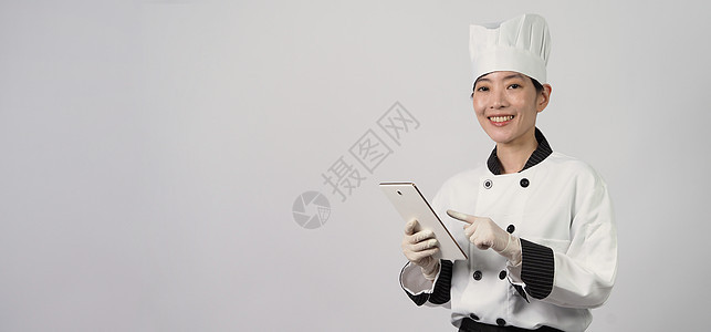 亚洲女厨师 手持数字平板电脑并领取食品订单居住工作手机互联网厨房商城网店企业家人士送货图片