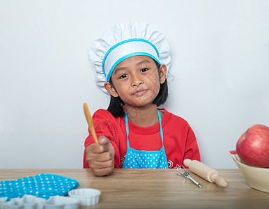 穿主厨制服的可爱女孩和装有模拟烹饪玩具的服装包c童年食物教育厨师桌子面粉喜悦厨房乐趣快乐图片