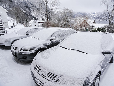 在挪威的雪景景观中埋有雪的汽车图片