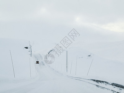 在挪威的雪路和风景中行驶森林木头运输乡村旅行暴风雪小路季节天气交通图片