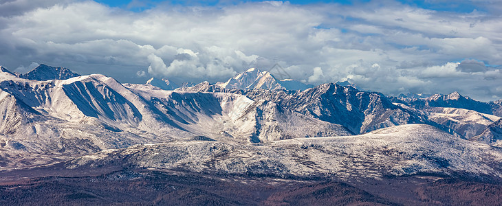 雪山山峰和北 Chuyskiy 山脊斜坡的风景全景鸟瞰图 美丽多云的蓝天作为背景 阿尔泰山脉 西伯利亚 俄罗斯图片