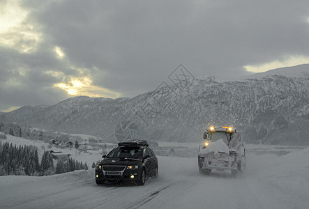 在挪威的雪路和风景中行驶天气乡村旅行季节小路木头森林运输暴风雪国家图片