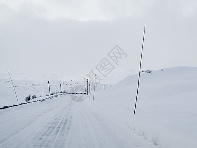 在挪威的雪路和风景中行驶暴风雪交通木头国家小路乡村运输森林天气季节图片